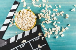 Top view of popcorn and movie clapper on wooden table, Movie time concept