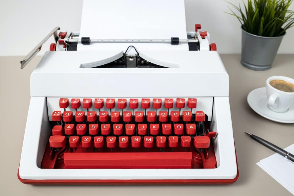 Retro typewriter with blank paper on desk