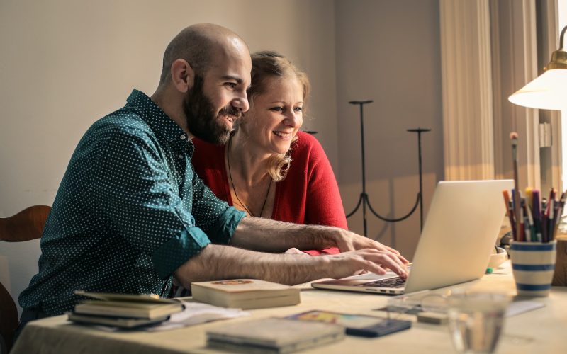 A man and a woman in front of a laptop