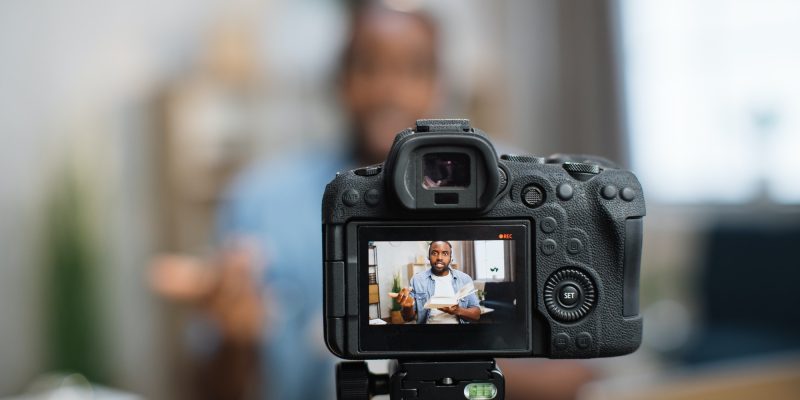 Modern camera with african american tutor on screen