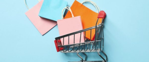 Shop cart with paper bags on blue background